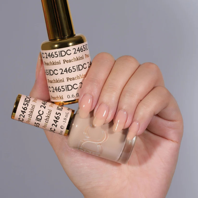 Hands wearing DND DC Gel 2465 Peachkini