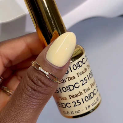 Hands wearing DND DC Gel 2510 Peach Tea