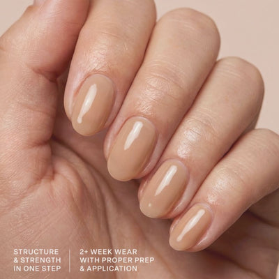 Model wearing Aprés Soft Gel Builder Gel Touch, featuring warm beige nude clean girl nails with a glossy structured gel manicure.