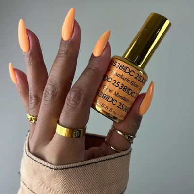 Hands wearing DND DC Gel 2538 Mandarin Glow