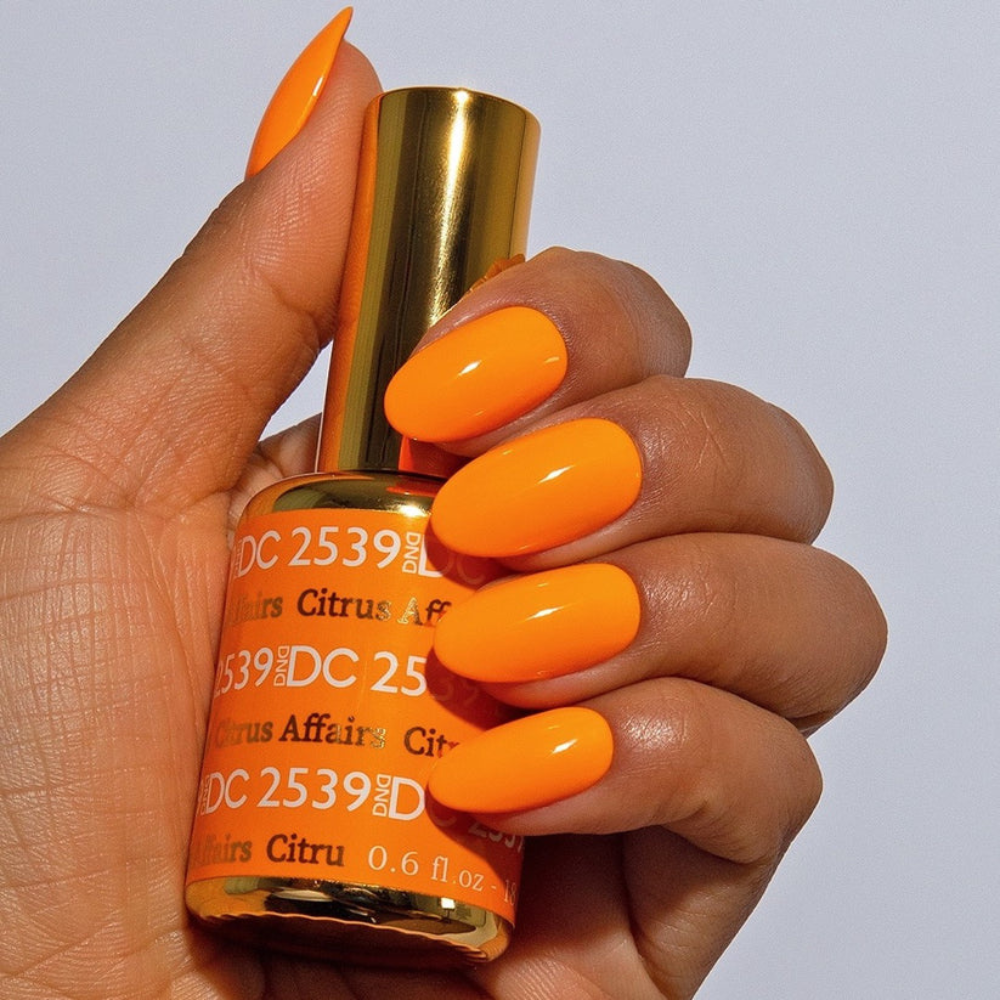 Hands wearing DND DC Gel 2539 Citrus Affairs