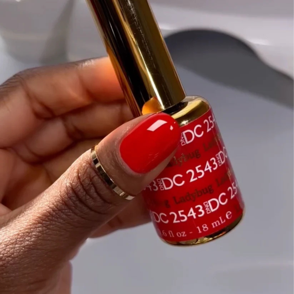 Hands wearing DND DC Gel 2543 Ladybug