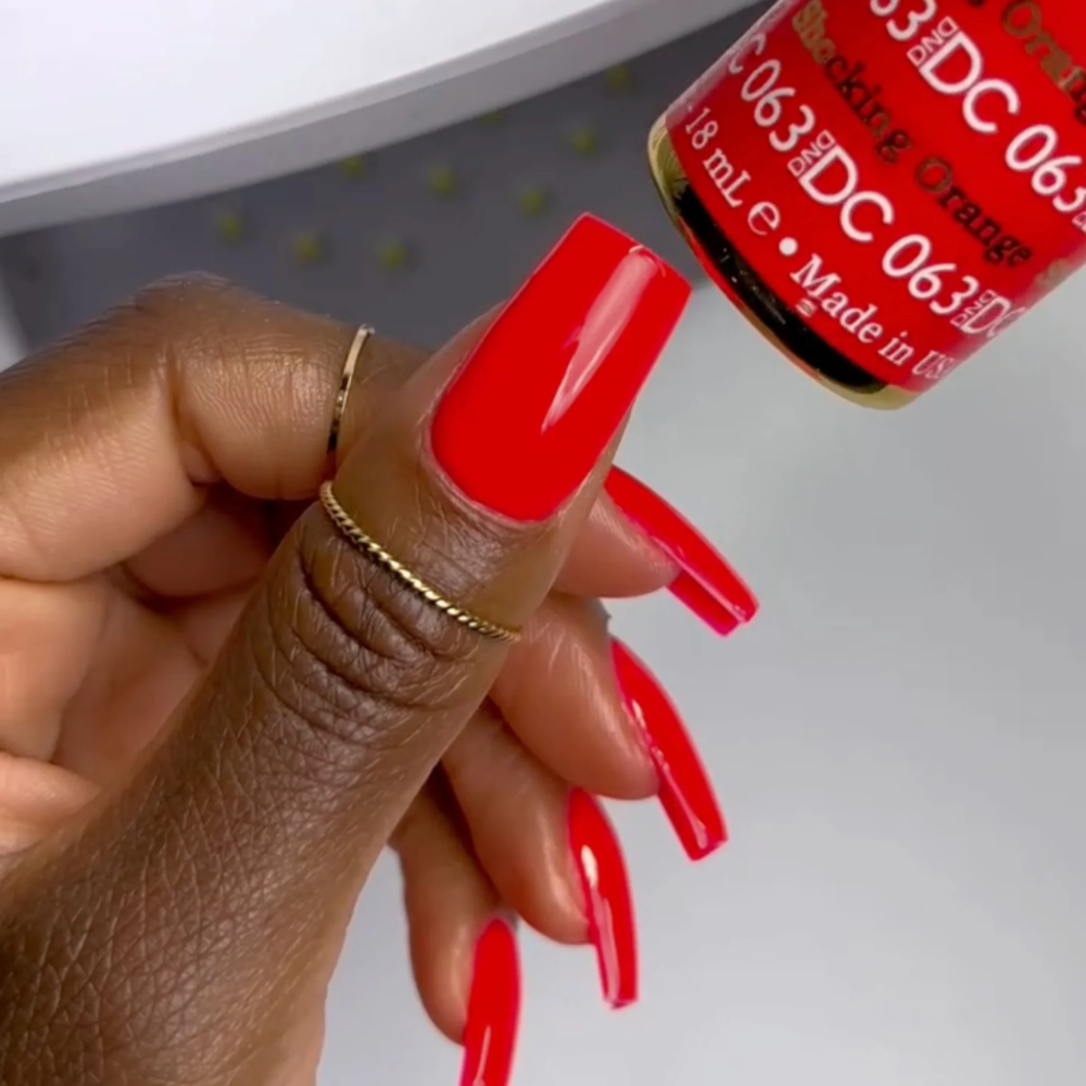 hands wearing DND DC Gel - 063 Shocking Orange