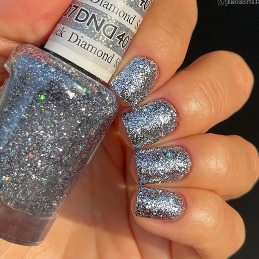 Hands wearing DND Gel 407 Black Diamond Star
