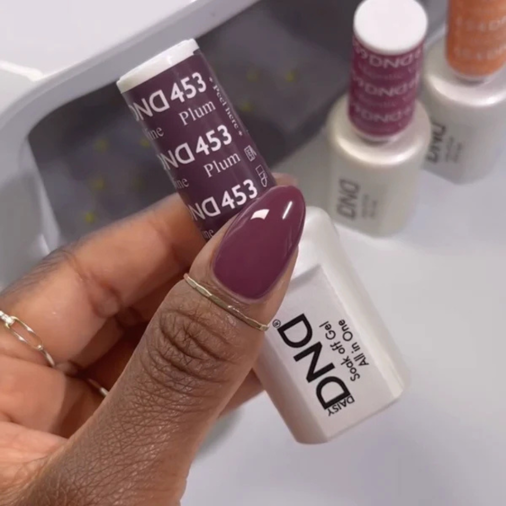 Hands wearing DND Gel 453 Plum Wine