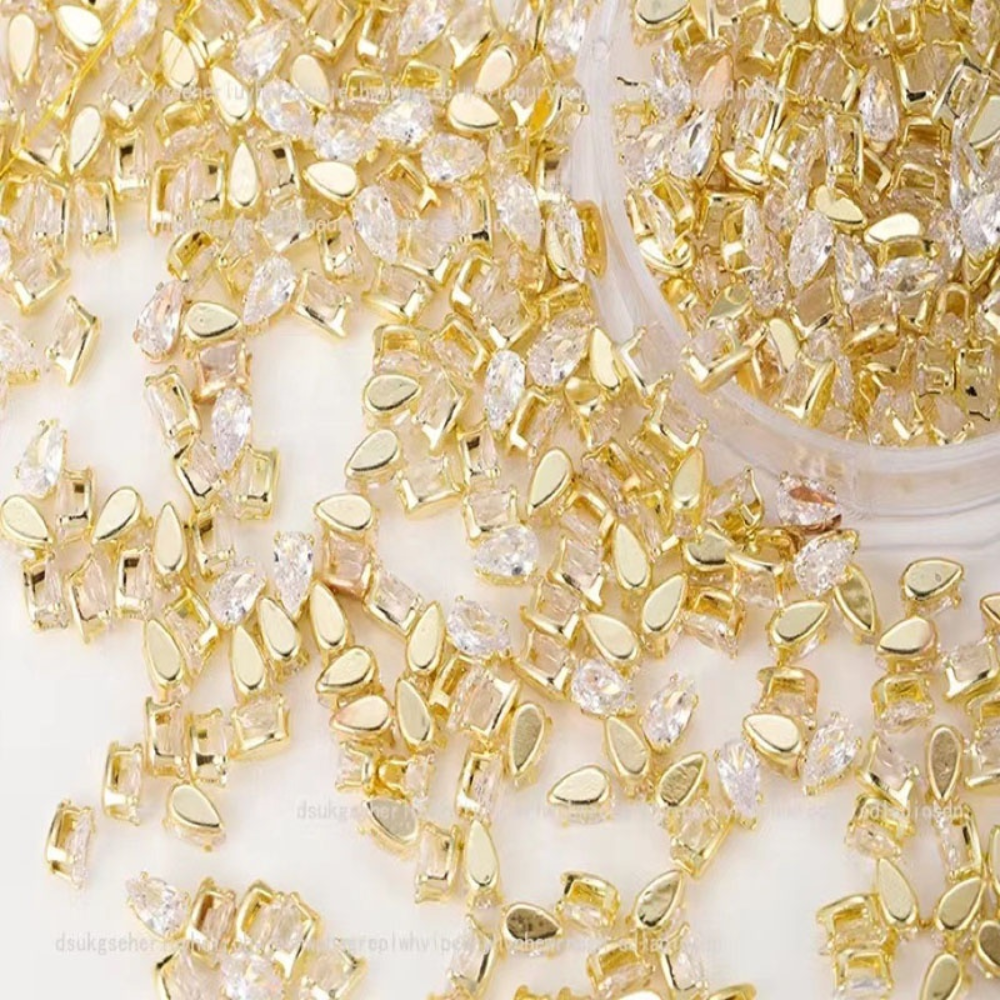 Mixed-shape clear nail crystals with gold frames for luxury nail art, Gel-X, builder gel, and acrylic manicures.