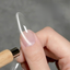 Halo Clear Cat Eye Gel swatch on a long clear nail showing a delicate silver magnetic line created with a cat-eye magnet.