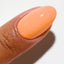 Finger wearing 2538 Mandarin Glow Gel & Polish Duo by DND DC