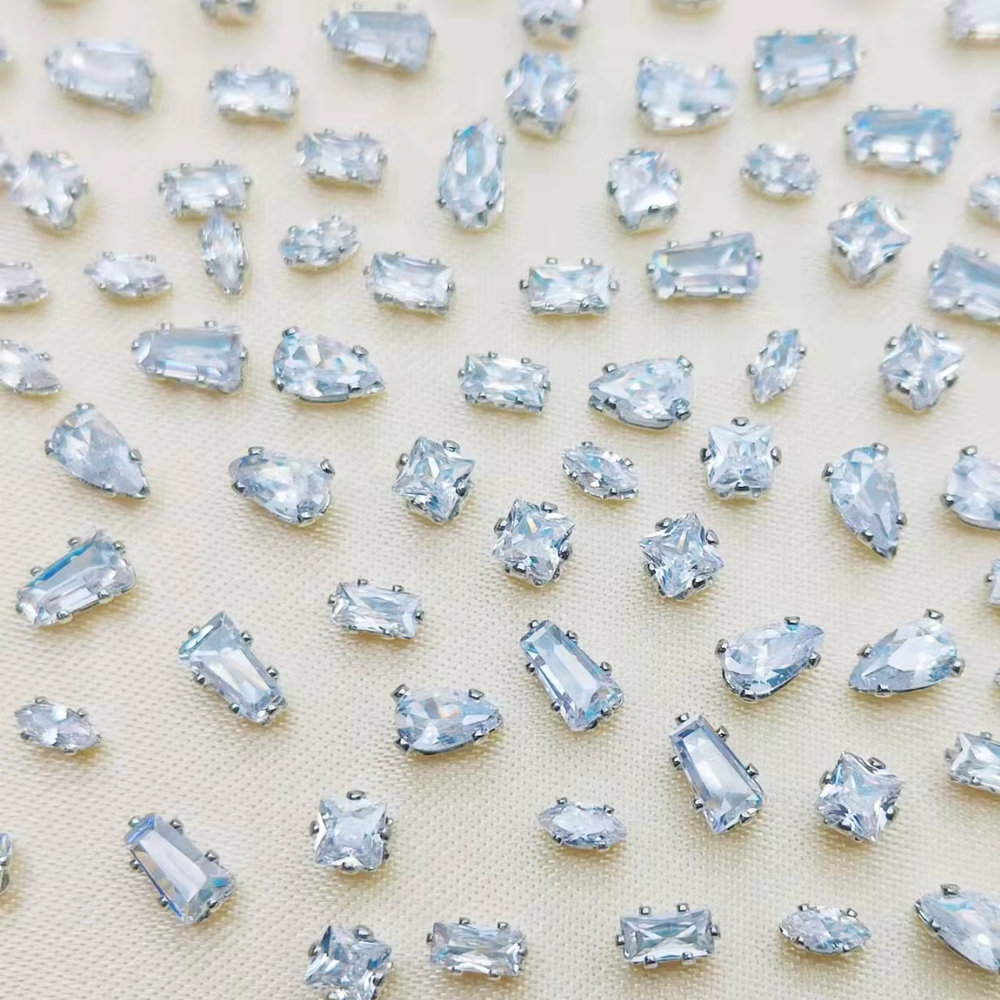 Mixed-shape clear nail crystals with silver frames for luxury nail art and professional manicures.
